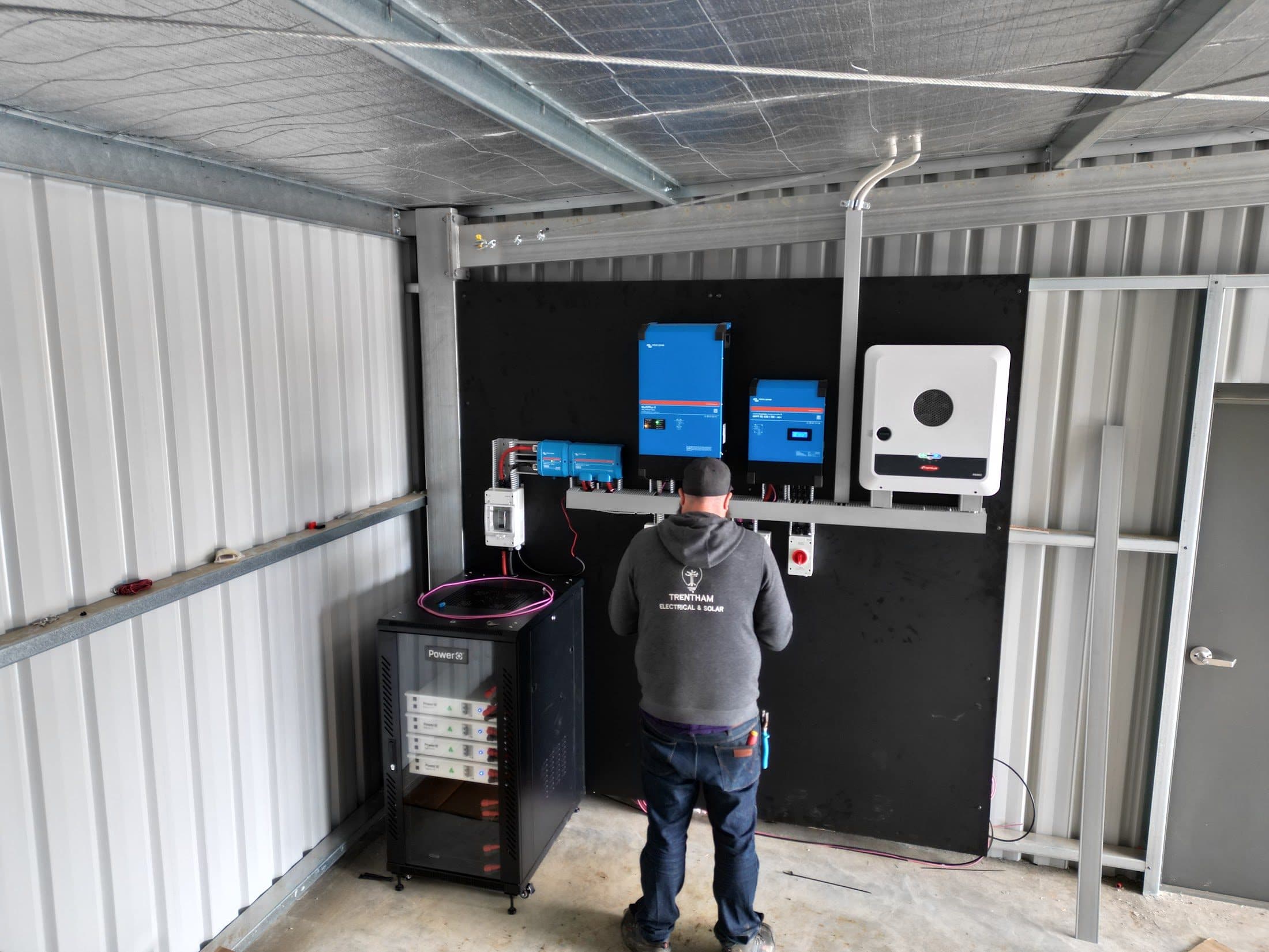 Commissioning twin Victron MultiPlus inverter chargers in the plant room at 244 Central Road